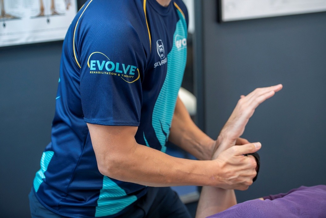 Physiotherapist treating patient for injury rehabilitation